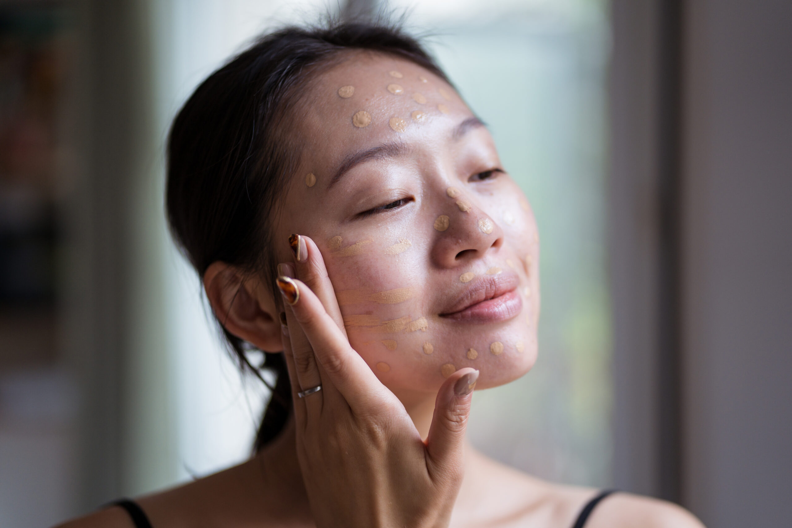 Satisfied Asian Visagiste Applying Foundation Cream On Face