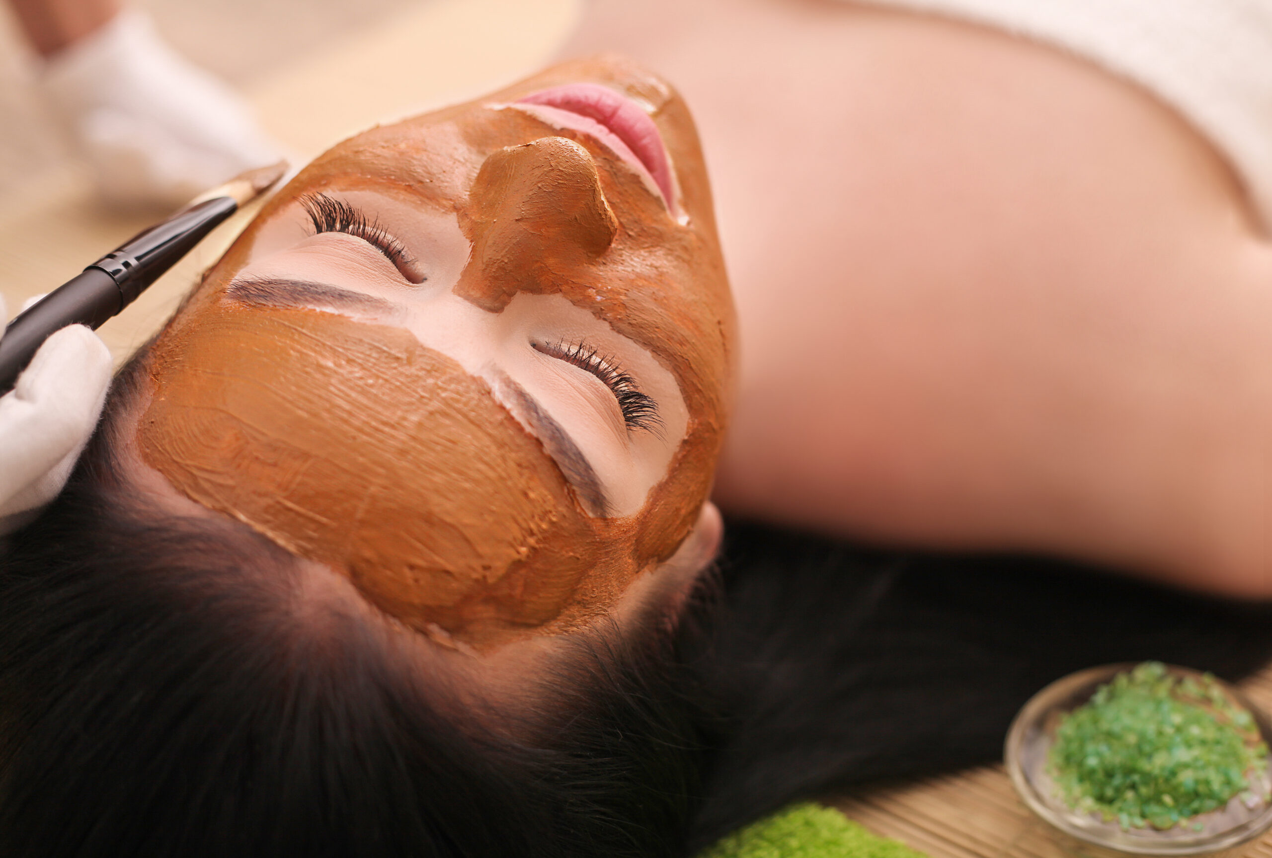 Spa Concept. Young Woman With Nutrient Facial Mask In Beauty Salon, Close Up